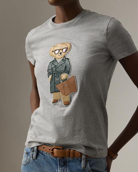 Our beloved mascot is appliquéd on this tee dressed in an outfit informed by the understated elegance that defines Pre-Autumn 2025 Collection. A team of six master embroiderers created the season's Racing Green Trench Polo Bear with highly considered materials, including synthetic leather for the bear's shoes, Ralph Lauren Tote and trench coat – whose colour is directly inspired by one of Mr Lauren's iconic vehicles – wool trench for the trousers, rib-knit cotton for the roll neck and metallic thread for the diamond earrings. This T-shirt is crafted with cotton jersey and finished with " Ralph Lauren Lauren" script embroidery.