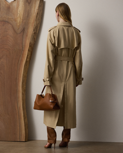 The Italian-made Alecia – realised here using traditional trench coat details, including buttoned shoulder epaulettes, storm flaps, a belted collar and waist and a double-breasted silhouette – is made from a silk-and-cotton fabric for a luxuriously soft and rich hand feel. Genuine horn buttons, lambskin-covered buckles and a calf-grazing length add refinement to its timeless design.