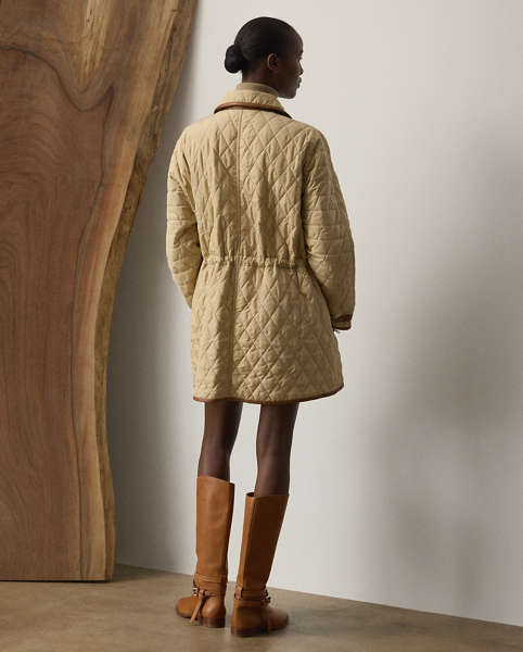 Quality comfort meets luxury in the season's Saundra coat, which is crafted with a finely woven, compact water-repellent fabric for a sturdy yet light weight and a soft, peachy hand feel. With an array of highly considered features, including a convenient two-way zip closure, zip pockets, an adjustable drawcord waist, latches at the throat and cuffs and interior padding for added warmth, this essential layer is finished with diamond quilting and lambskin trim throughout.