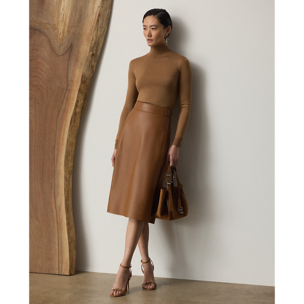 Evoking the sleek, clean aesthetic that defines Pre-Autumn 2025 Collection, the Jackeline midi skirt is cut for a subtle A-line silhouette that hits just below the knee. Designed with a wrap closure that easily secures with an engineered buckled waistband and an interior snapped closure, this timeless style is crafted in Italy from supple nappa lambskin that's specially dyed and finished to achieve its rich coloring.