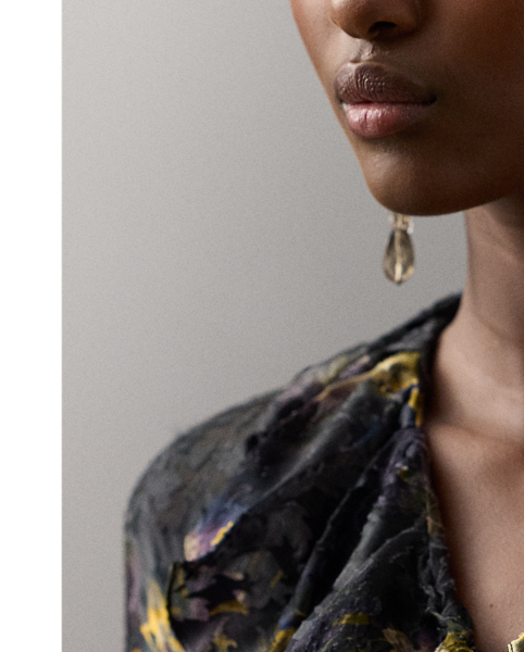 The Carol jumpsuit embodies the modern, romantic aesthetic that defines Autumn 2025 Collection. Featuring Victorian-inspired design elements, including ruffles along the neckline and at the sleeve cuffs, this straight-leg jumpsuit is crafted in Italy from a special satin fabrication printed with the season's lilac motif, which was first hand-painted in-house by  Ralph Lauren Lauren artists, then reproduced as a print in a renowned Como, Italy, mill. To achieve the fabric's watercolour effect, this style undergoes two different printing techniques: first traditionally printed, then with a devoré technique, which dissolves the viscose yarns to leave a slightly transparent silk base. Adjustable self-ties create a versatile neckline that can be styled open or closed, allowing you to switch up your look with ease.