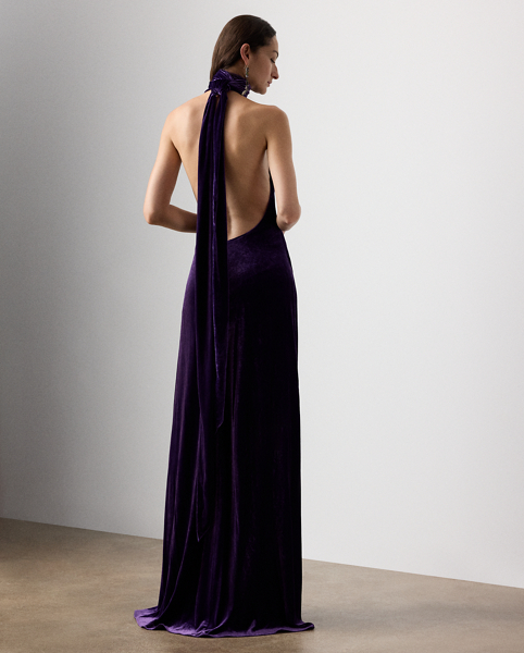 Inspired by Ralph Lauren Lauren's iconic Chilton dress, the Tatum showcases Mr Lauren's ability to transform timeless silhouettes into modern designs. Crafted in Italy from lightweight, comfort stretch velvet for a remarkable drape and beautiful sheen, this evening gown is distinguished by a halter neckline with a dramatic scarf that cascades gracefully down the body. Its figure-skimming column silhouette features an engineered skirt slit that starts at the back, then wraps around to the front for ease of movement.