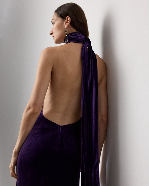 Inspired by Ralph Lauren Lauren's iconic Chilton dress, the Tatum showcases Mr Lauren's ability to transform timeless silhouettes into modern designs. Crafted in Italy from lightweight, comfort stretch velvet for a remarkable drape and beautiful sheen, this evening gown is distinguished by a halter neckline with a dramatic scarf that cascades gracefully down the body. Its figure-skimming column silhouette features an engineered skirt slit that starts at the back, then wraps around to the front for ease of movement.