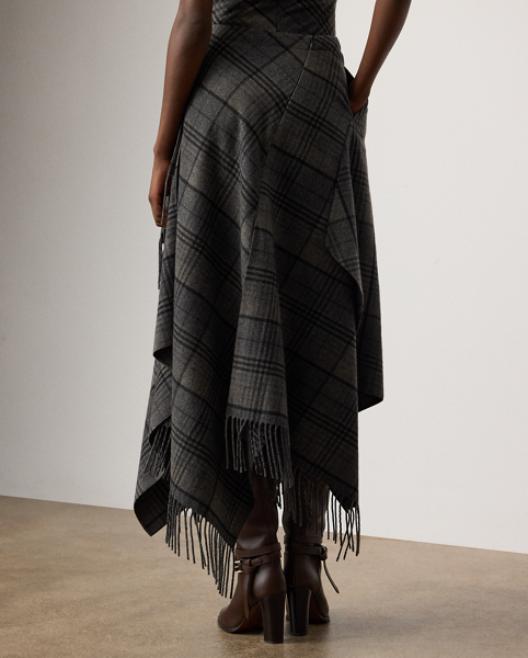 Distinguished by its faux-wrap design, the calf-grazing Hadiah skirt features a front overlay and a handkerchief hem with fringe trim. Reminiscent of vintage Ralph Lauren Lauren plaid tailoring, this skirt's fibre-dyed Italian wool fabric is redeveloped for a softer hand and lighter weight, making it perfect for transitional dressing.