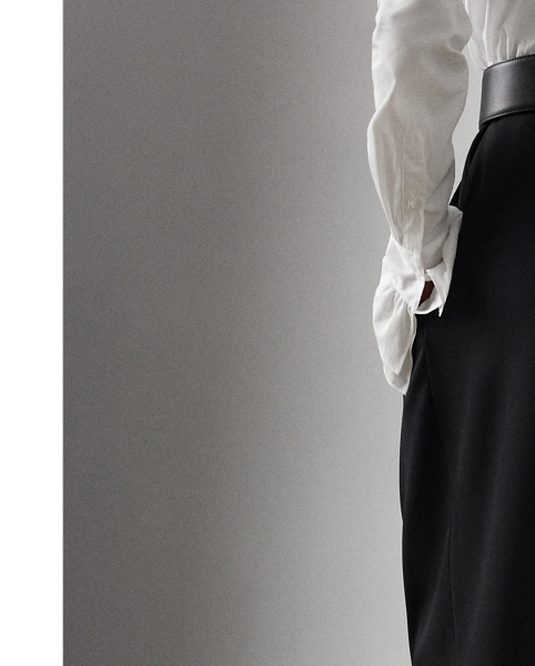 Crafted in Italy with wool trench in a compact weave specially selected for its structured form and stunning drape, the Jeanne trouser features a low-rise, relaxed-fitting silhouette that elegantly tapers toward the hem – a comfortable yet flattering silhouette enhanced by buttoned tabs at the ankles.