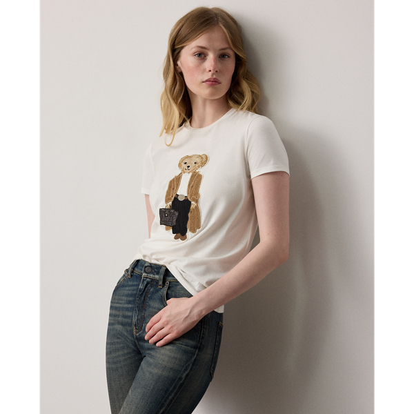 For Autumn 2025, Mr Lauren was inspired by the intricate beauty of Victorian-era designs, which is evident in the season's Autumn Polo Bear tee. Four specialised technicians created the Polo Bear patch using a mix of embroidery techniques and a collection of highly considered materials, including a rich wool blend for the coat, soft cotton-and-silk voile for the blouse, wool flannel for the trousers and dry-cleanable lambskin for the Ricky bag. Additional details, including embroidered neck lace and a special thread technique for the pinstripes and rodeo buckle, nod to the season's focus on the finer details. This T-shirt is crafted with cotton jersey and finished with " Ralph Lauren Lauren" script embroidery.