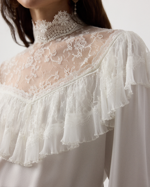 Inspired by the timeless beauty of vintage styles, the Alexandrea unites a collection of luxurious fabrics to achieve its romantic look. Starting with highly twisted crepe yarns woven in a satin weave for the body, three highly trained artisans embroidered the tulle fabric at the neck, creating a cotton lace effect. After carefully studying the fabric, the lace and tulle ruffle are pleated and trimmed, showcasing Ralph Lauren Lauren's commitment to fine crafting and attention to detail.