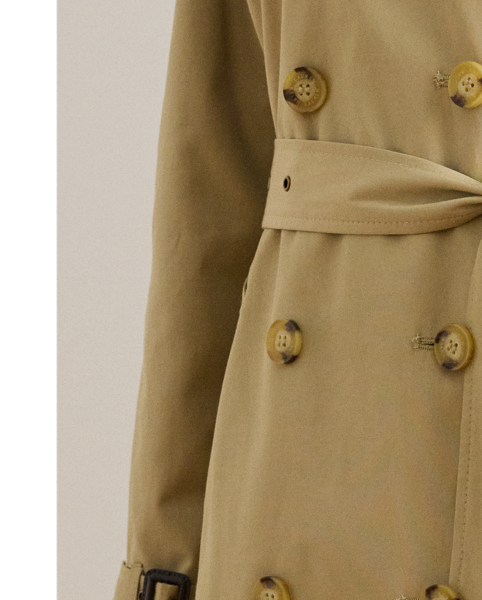 A buckled self-belt enhances the streamlined silhouette of this double-breasted trench coat, which is tailored with a lightweight cotton blend. Buttoned shoulder epaulets and “Lauren  Ralph Lauren Lauren”-engraved horn-effect buttons amp up its sophisticated appeal, while storm flaps and a water-resistant shell protect you from inclement weather.