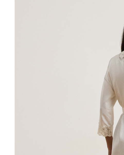 The luxuriously smooth hand of satin lends a subtle sheen to this robe, while delicate lace trim enhances its romantic allure. A self-belt on the waist creates a defined silhouette.