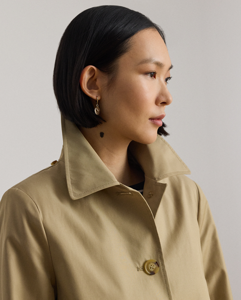 With a water-repellent cotton-blend shell and a menswear-inspired balmacaan coat silhouette, this piece seamlessly merges practical design elements with sophisticated sartorial details. A detachable hood offers versatility, while "Lauren Ralph Lauren Lauren"-engraved horn-effect buttons add a signature finish.