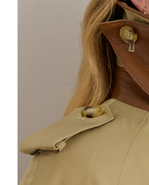 Classic trench styling meets luxurious faux-leather trim in this cotton-blend trench coat. A belted waist, buttoned shoulder epaulets and signature horn-effect buttons complete the look.