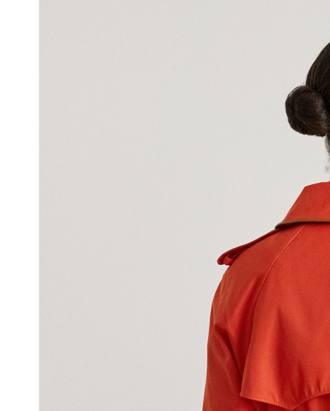 Classic trench styling meets luxurious faux-leather trim in this cotton-blend trench coat. A belted waist, buttoned shoulder epaulets and signature horn-effect buttons complete the look.