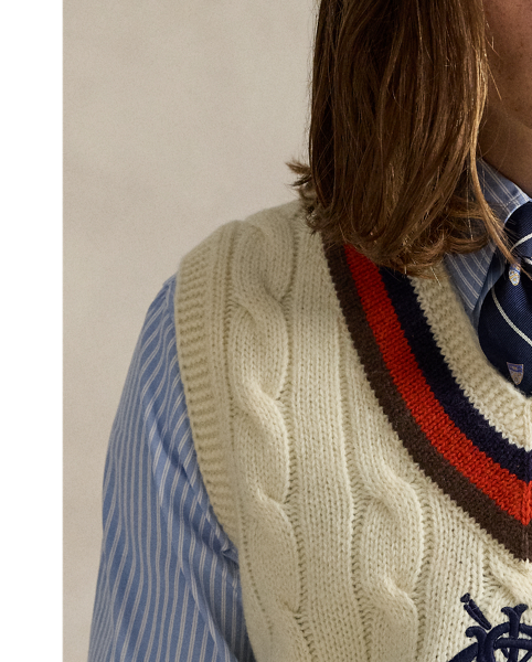 The cricket jumper is defined by its cable-knit pattern, usually in cream, as well as its V-neck and striped trim, which traditionally represents school or club colours. Part of the season's collection inspired by New England's storied regatta tradition, this version is embroidered with a signature crest and oars.