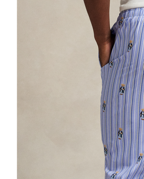 These striped woven cotton pyjama trousers feature an allover pattern of the Polo Bear wearing  Ralph Lauren Lauren's iconic cricket jumper and madras trousers.