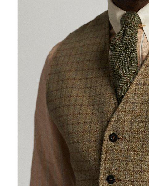 Made with checked wool tweed that was custom-developed with an Italian mill. Fibre-dyed mélange fabric features an open-weave construction. Adjustable buckled back. fully lined. Corozo buttons.